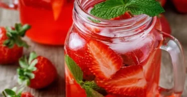 Fruchtige Erdbeerbowle in einem Gläser auf einem Tisch im Sommer