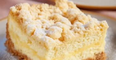 Käsekuchen mit Streusel auf einem Teller serviert, verziert mit frischen Früchten.