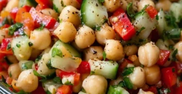 Kichererbsensalat mit frischem Gemüse und Kräutern auf einem weißen Teller