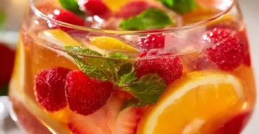 Schmackhafte alkoholische Bowle mit frischen Früchten und bunten Zutaten