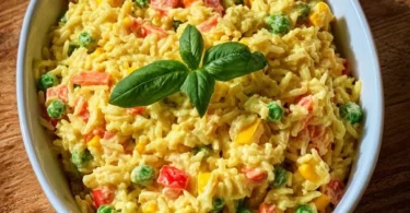 Bunter Reissalat mit Curry in einer Schüssel, verziert mit frischem Gemüse