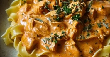 Cremiges Hähnchenragout mit Bandnudeln auf einem Teller serviert